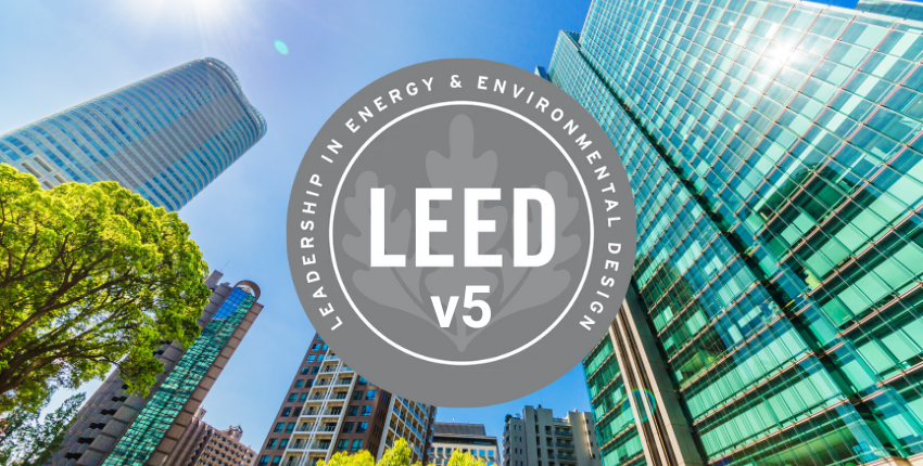 Circular grey LEED v5 logo emblem with skyscraper buildings in the background